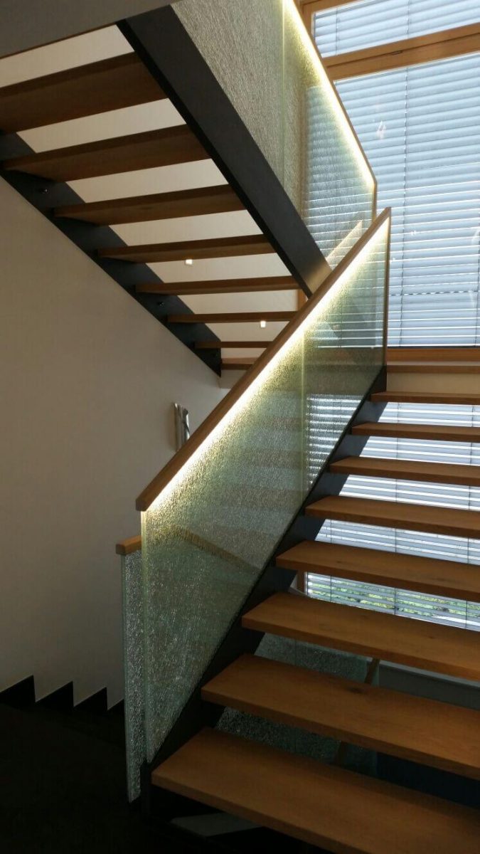 Moderne Innentreppe mit offenen Holzstufen, strukturiertem Glasgeländer und integrierter LED-Beleuchtung für stilvolle Akzente