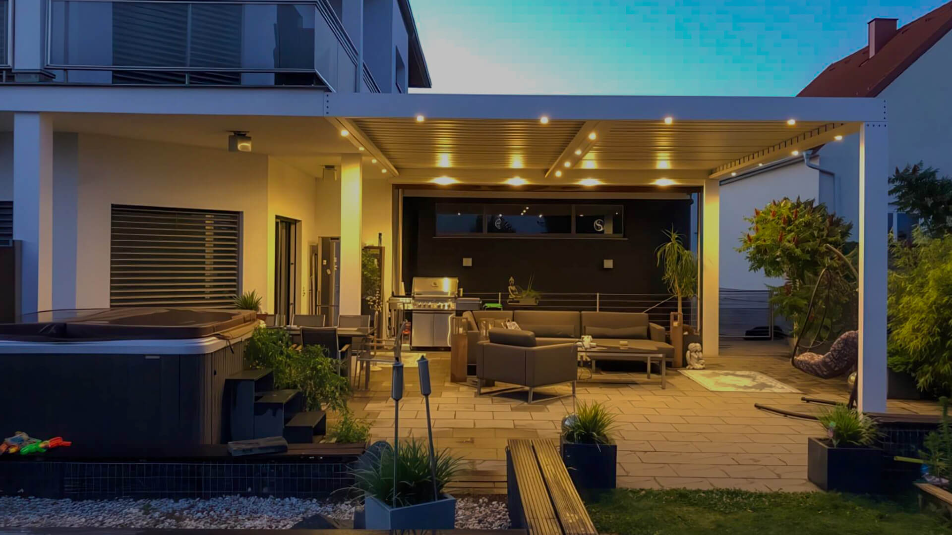 Großzügige moderne Terrassenüberdachung aus Aluminium mit integrierter LED-Beleuchtung, gemütlicher Lounge-Ecke und Outdoor-Küche